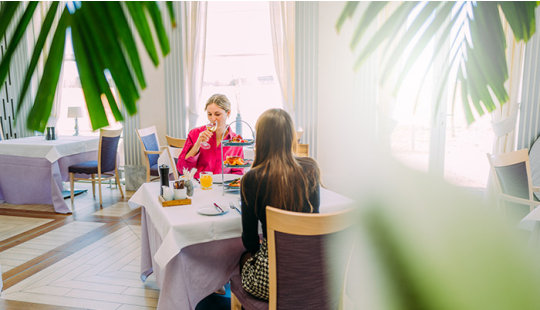 Zwei Frauen sitzen an einem gedeckten Tisch des Restaurant Empire.